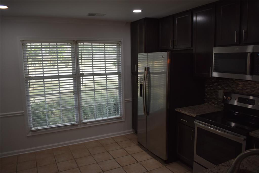 131 Willow Stream Court Roswell, GA 30076 - Photo 10 of 25 a kitchen with a refrigerator and a stove top oven