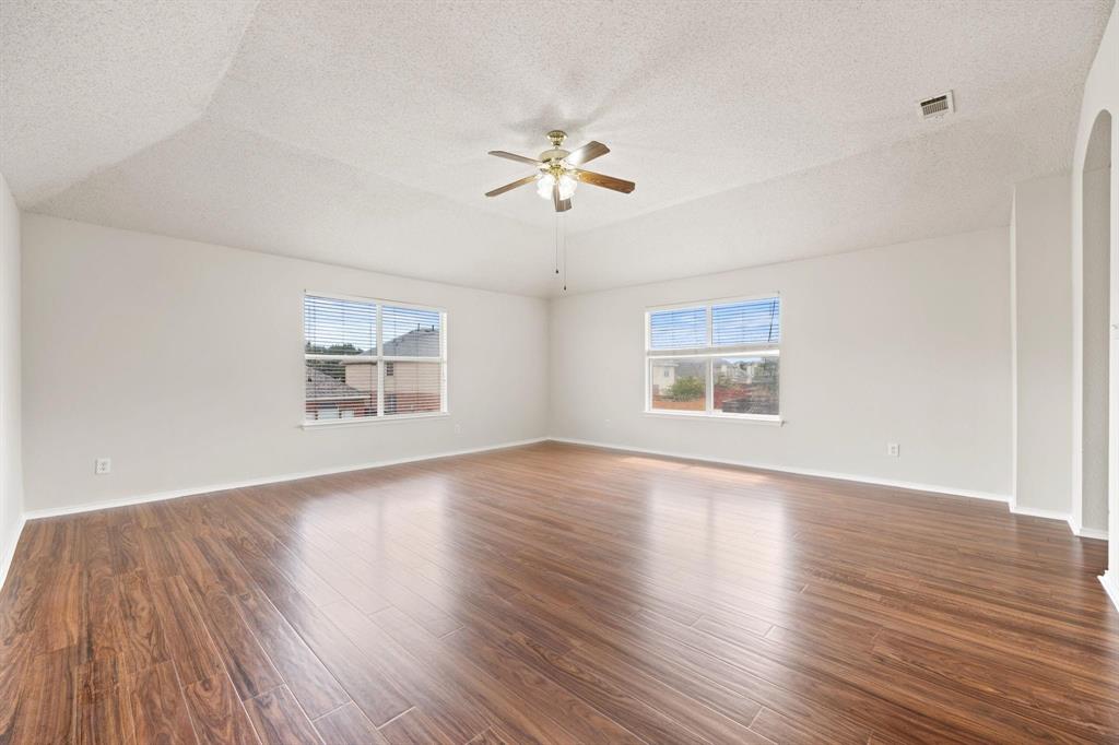 433 Spring Air Drive Allen, TX 75002 - Photo 13 of 27 an empty room with wooden floor chandelier fan and windows