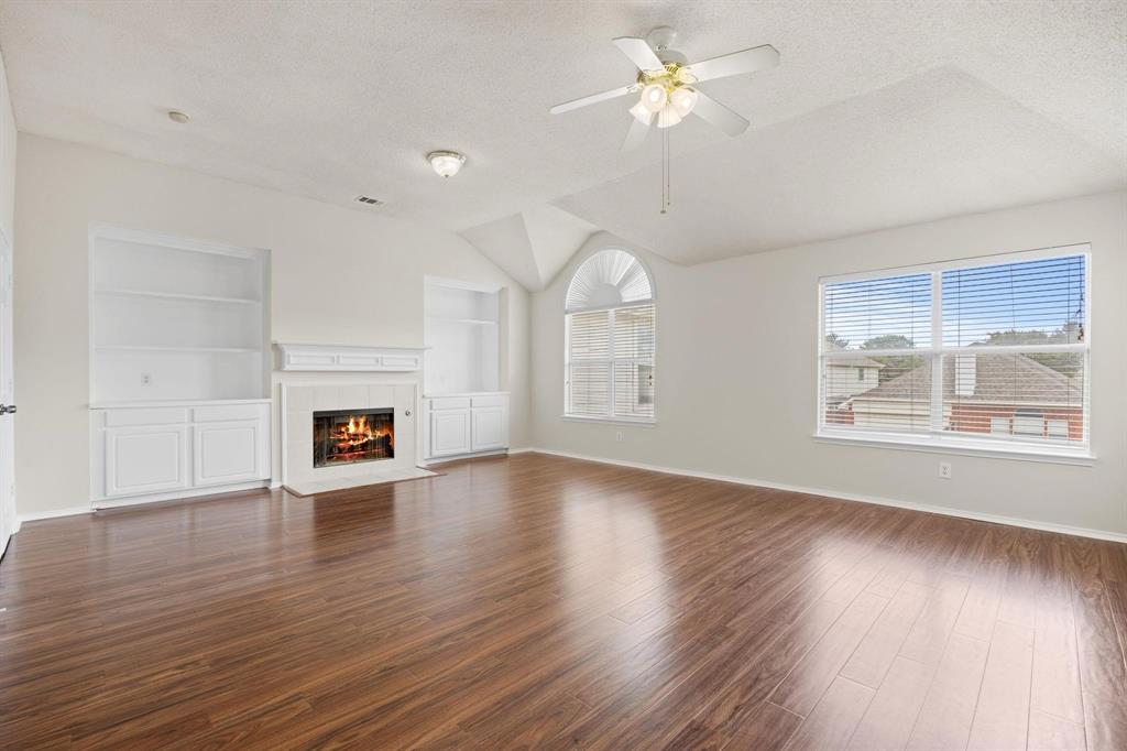 433 Spring Air Drive Allen, TX 75002 - Photo 14 of 27 a view of a livingroom with wooden floor a ceiling fan and windows