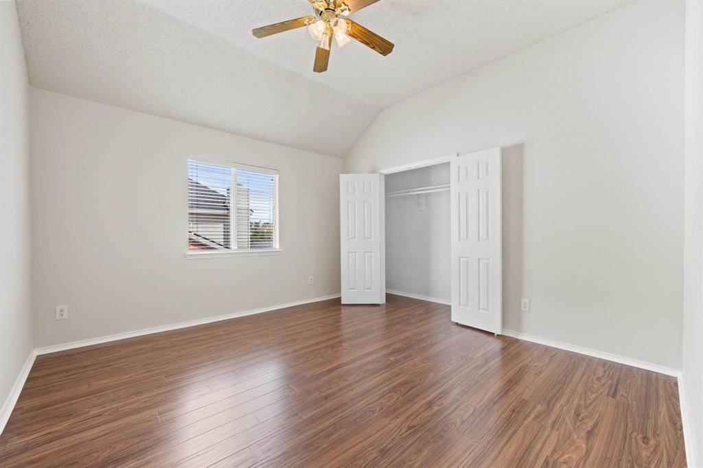 433 Spring Air Drive Allen, TX 75002 - Photo 20 of 27 an empty room with wooden floor chandelier fan and windows