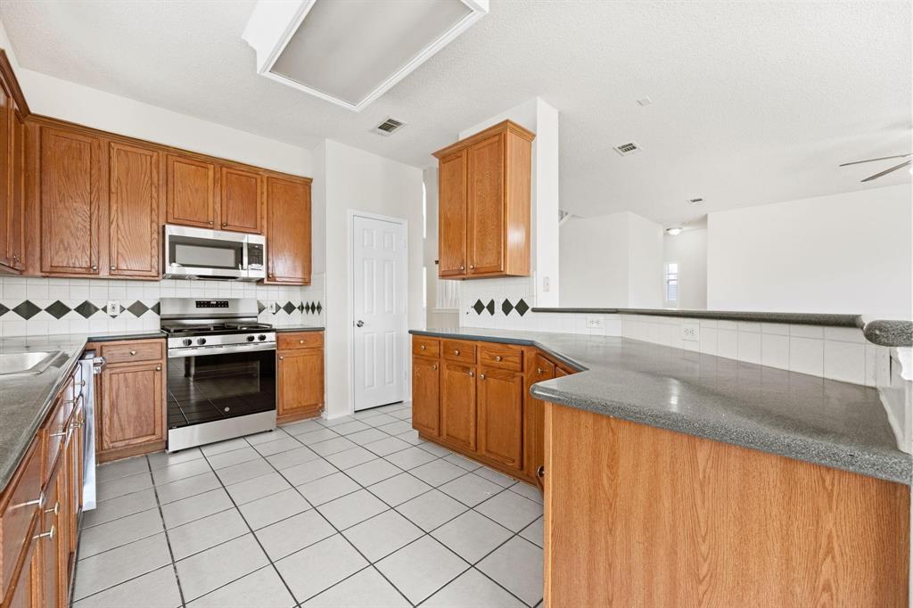 433 Spring Air Drive Allen, TX 75002 - Photo 9 of 27 a kitchen with stainless steel appliances granite countertop a stove a sink and a microwave