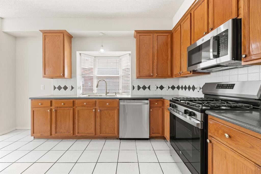 433 Spring Air Drive Allen, TX 75002 - Photo 10 of 27 a kitchen with stainless steel appliances granite countertop a stove a sink and a microwave