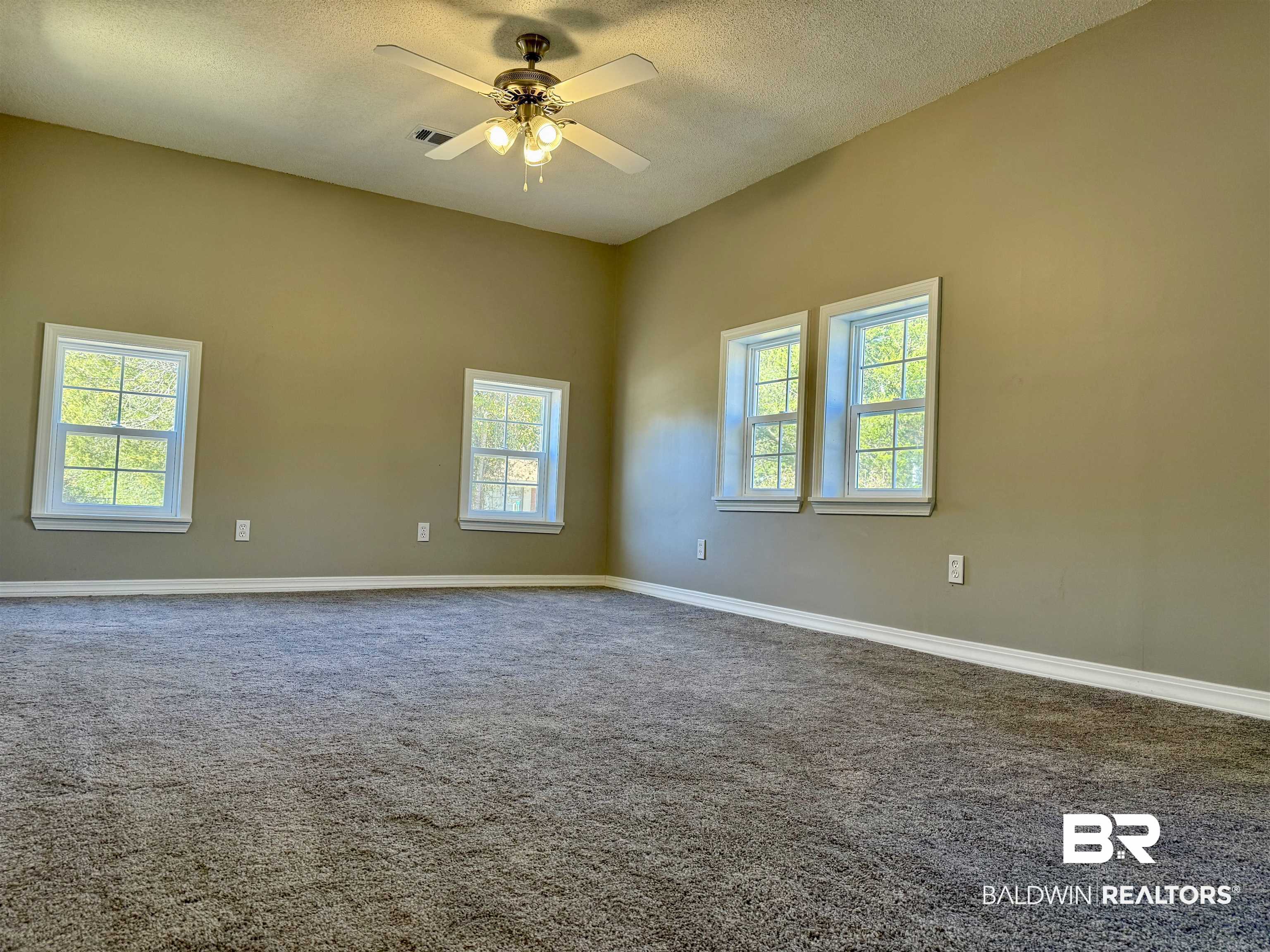 205 Schad Street Brewton, AL 36426 - Photo 3 of 11 Empty room with a textured ceiling, carpet, and a ceiling fan