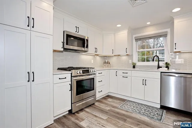 a kitchen with stainless steel appliances granite countertop a stove microwave and sink