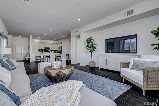 a living room with furniture and a view of kitchen
