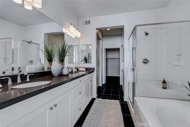 a bathroom with a double vanity sink a large mirror and a shower