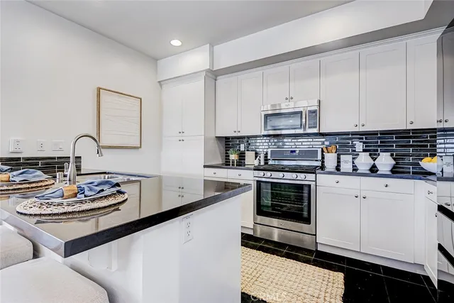 a kitchen with stainless steel appliances a stove a sink and cabinets