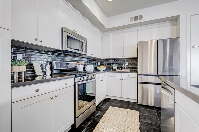 a kitchen with stainless steel appliances a refrigerator sink and cabinets