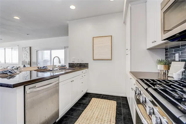 a kitchen with sink stove and cabinets