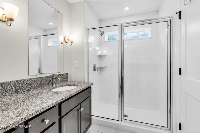 a bathroom with a granite countertop shower sink and mirror