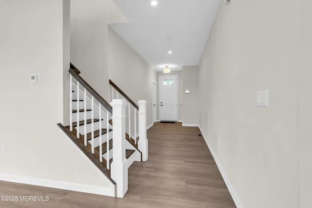 a view of a hallway with wooden floor and entryway