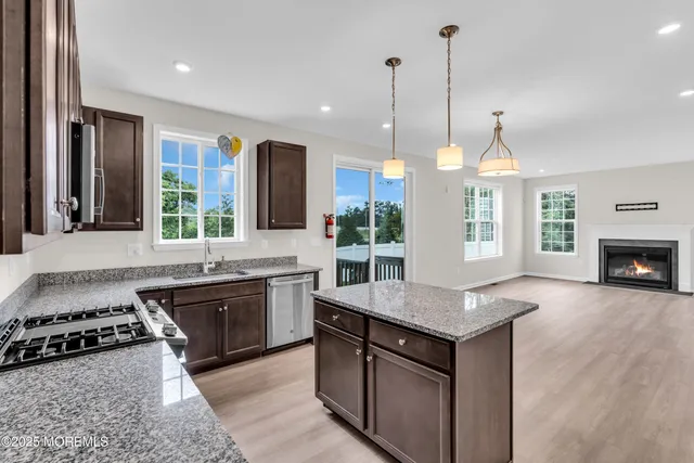 a kitchen with kitchen island granite countertop a stove and a sink