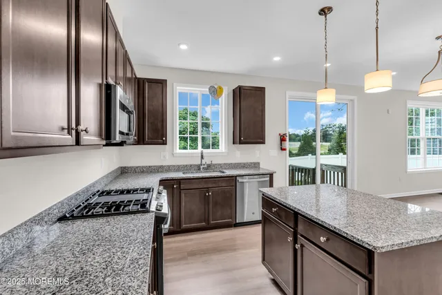 a kitchen with stainless steel appliances granite countertop stove a sink and a refrigerator