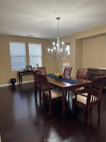a view of a dining room with furniture wooden floor and chandelier