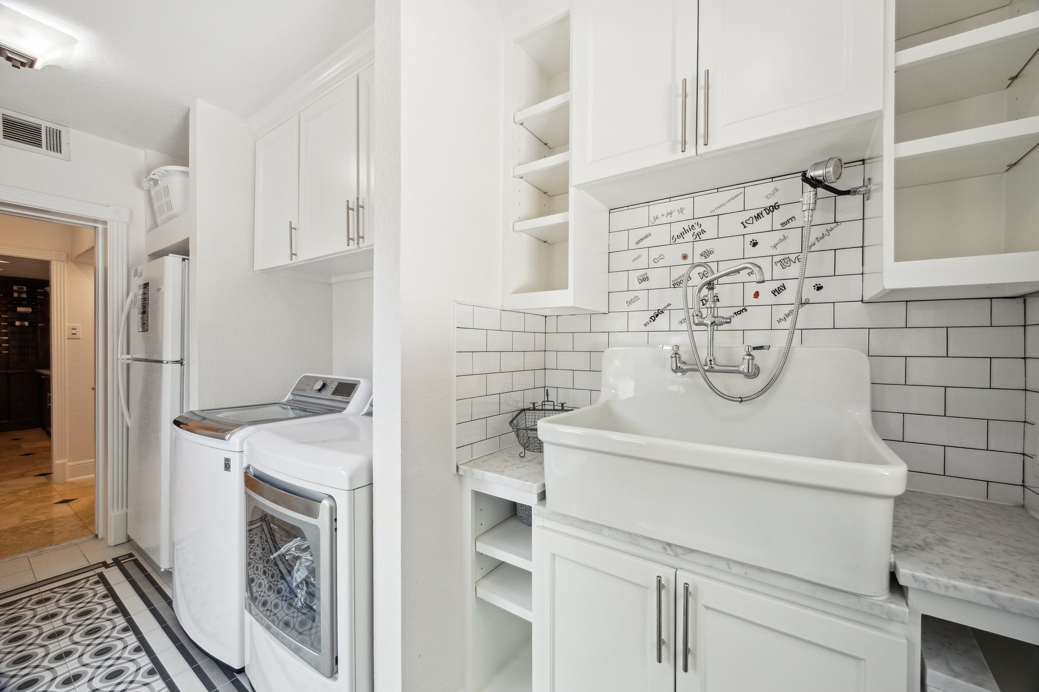 1917 Anchor Way Dickinson, TX 77539 - Photo 24 of 48 A SIDE DOOR ENTRANCE INTO THE MUD ROOM UTILITY AREA OFFERS A WASHER/DRYER AND ADDITIONAL FRIDGE/FREEZER AREA. A CUSTOM SINK TO BATH YOUR PUP AND HAND WASH DELICATE CLOTHING IS SURROUNDED BY CUSTOM BUILT-IN CABINETS AND SHELVING