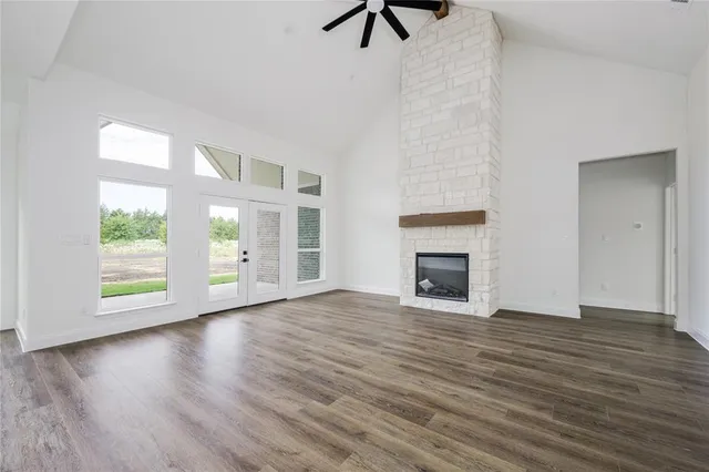a view of empty room with wooden floor and fireplace