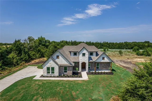 a front view of a house with a garden and yard