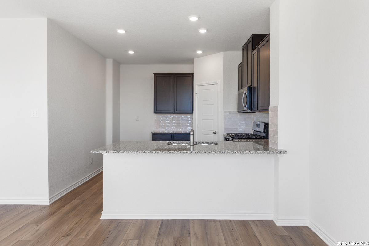 10030 Jagger Avenue Converse, TX 78109 - Photo 12 of 28 a view of a kitchen with kitchen island a sink wooden floor and a counter top space