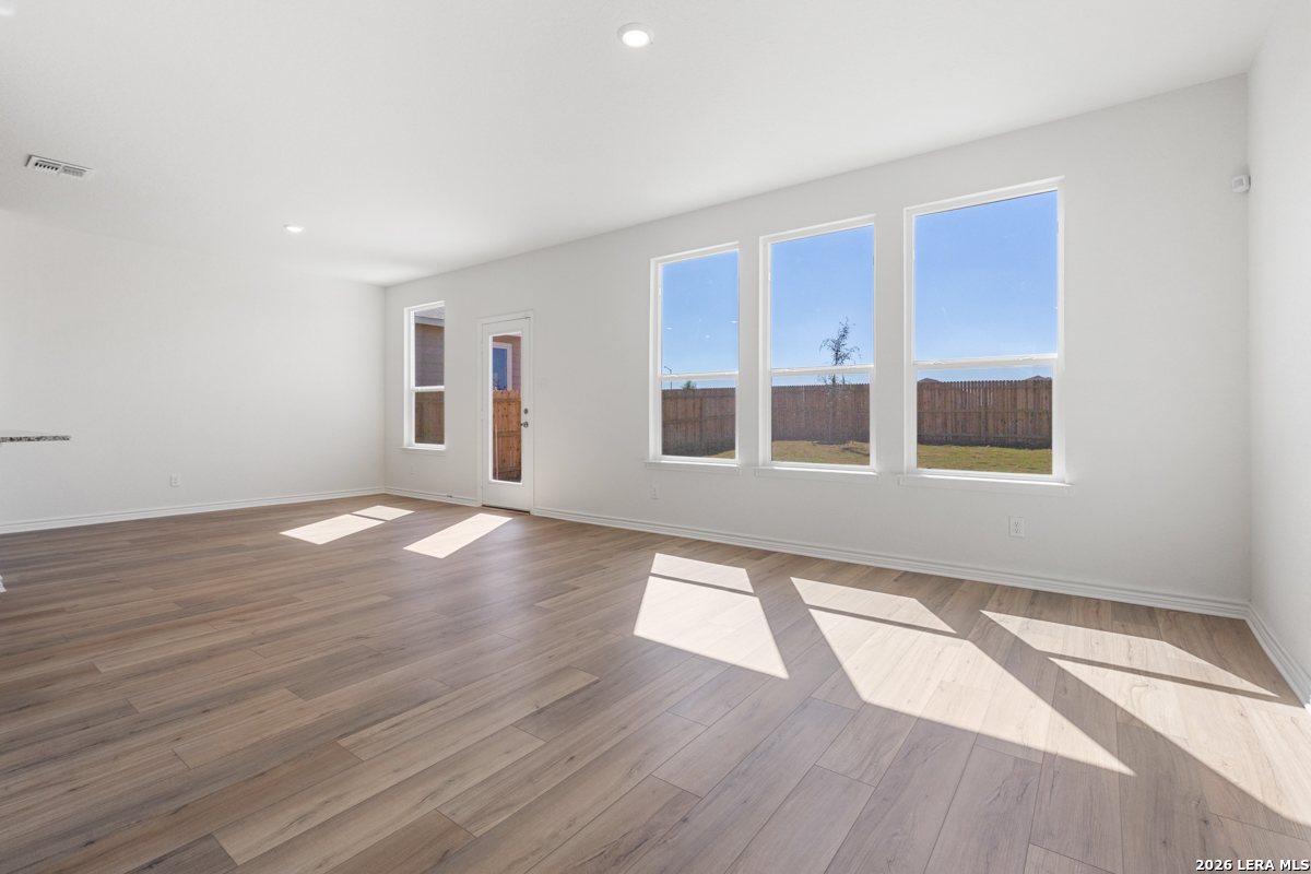 10030 Jagger Avenue Converse, TX 78109 - Photo 9 of 28 a view of an empty room with wooden floor and a window