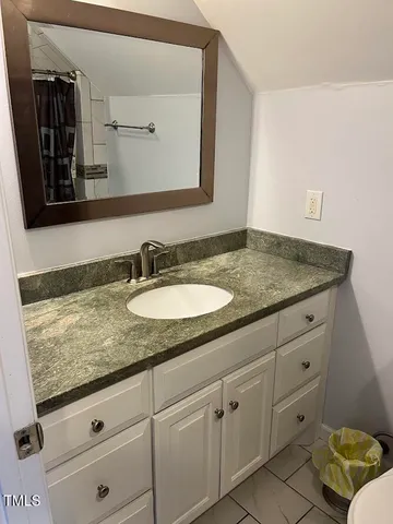a bathroom with a granite countertop sink and a mirror