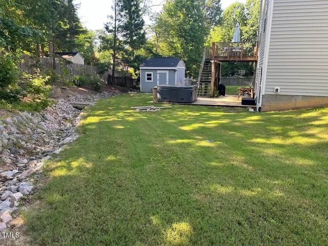 a view of a house with a big yard and large tree