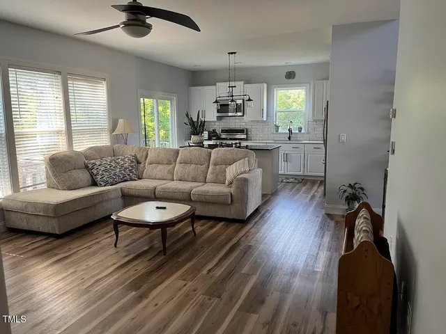 a living room with furniture and a wooden floor