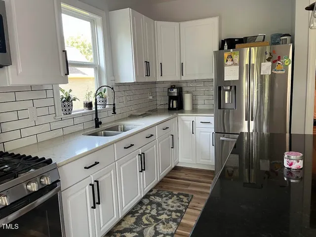 a kitchen with granite countertop a refrigerator and a sink