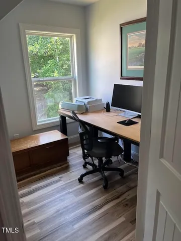 a view of a workspace with furniture and a window