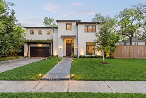 a front view of a house with a yard and a garage