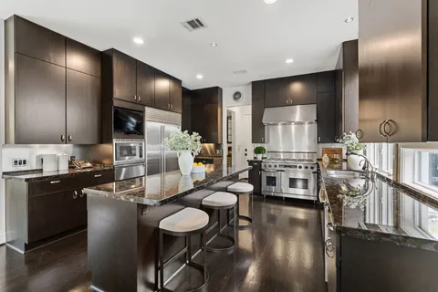 a large kitchen with kitchen island granite countertop lots of counter top space and stainless steel appliances