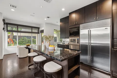a kitchen with a table chairs refrigerator and microwave