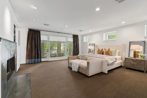 a spacious bedroom with a large bed and a fireplace