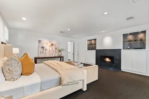a spacious bedroom with a bed and a fireplace