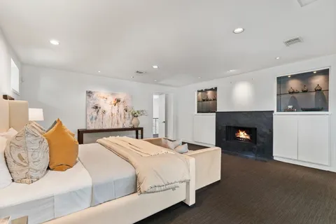 a large white kitchen with stainless steel appliances kitchen island granite countertop a lot of counter space and a sink