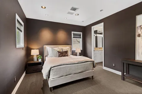a bedroom with a bed and a flat tv screen on dresser