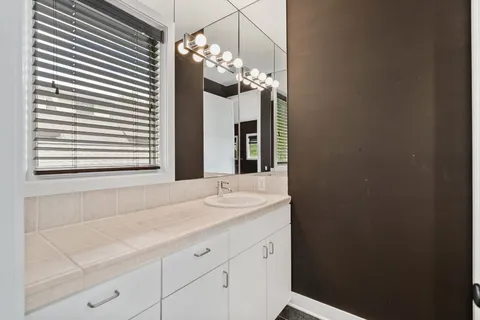 a bathroom with a double vanity sink mirror and shower