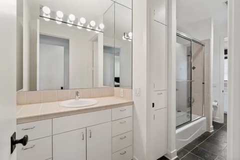 a bathroom with a double vanity sink mirror and shower