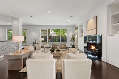 a living room with fireplace furniture and a large window