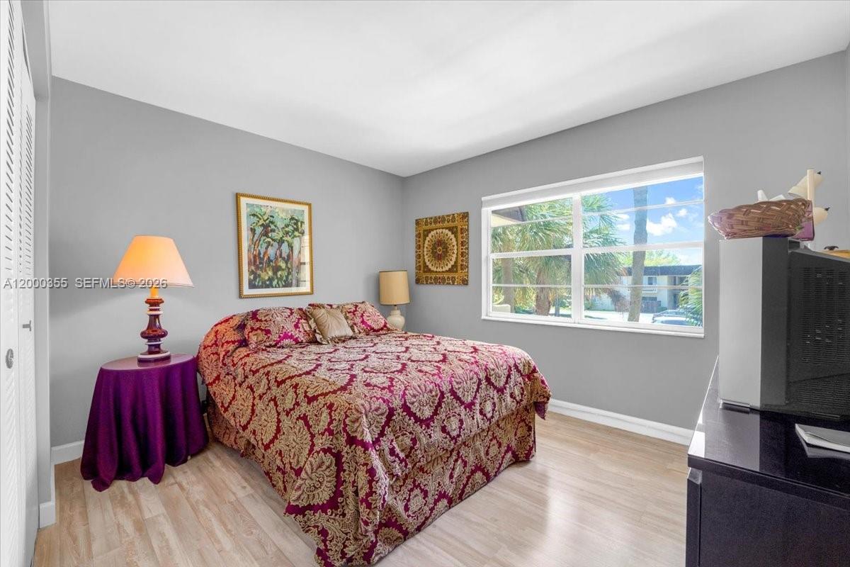 9009 Southwest 138th Street, Unit 202 Miami, FL 33176 - Photo 12 of 23 a bedroom with a bed and a flat tv screen on dresser