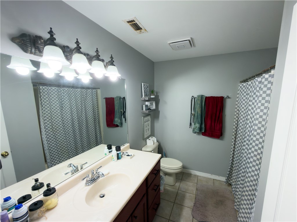 164 Park Road Russellville, AR 72802 - Photo 9 of 35 Bathroom featuring a dark wood-finish vanity with a single basin sink, an expansive wall-mounted mirror, and overhead decorative lighting