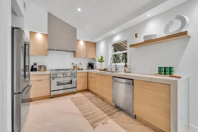 a kitchen with a sink window and stainless steel appliances