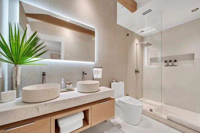 a bathroom with a granite countertop sink a toilet a mirror and shower