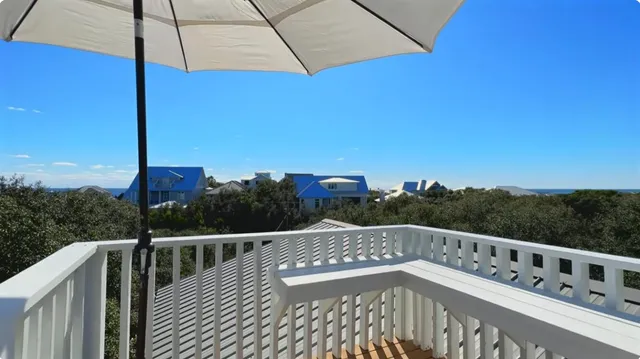 a view of a balcony with wooden floor and fence