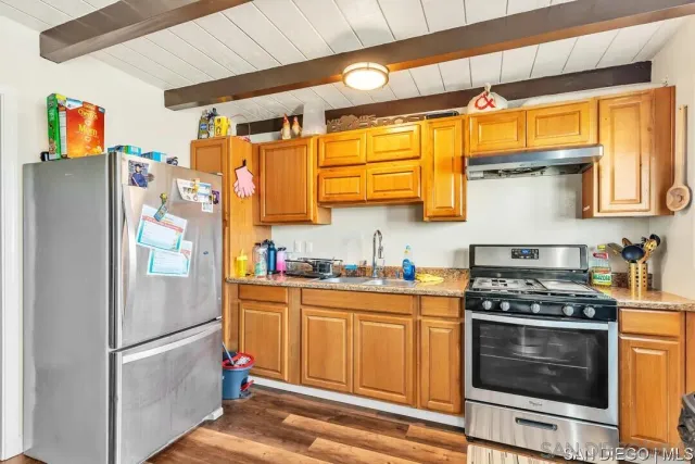 a kitchen with stainless steel appliances granite countertop a refrigerator and a stove top oven