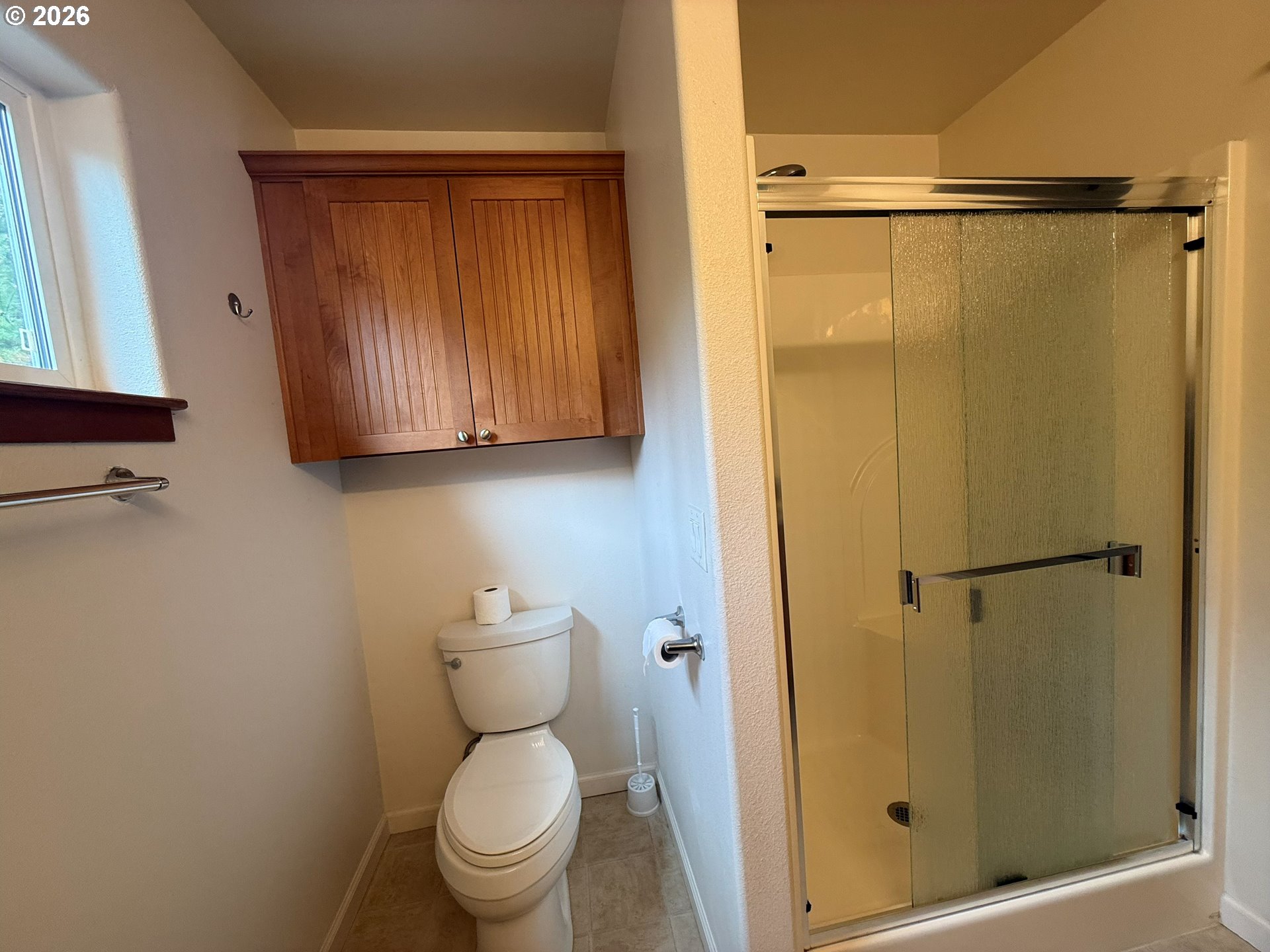 4797 Cloudcroft Lane Florence, OR 97439 - Photo 20 of 33 a bathroom with a shower a toilet and a window