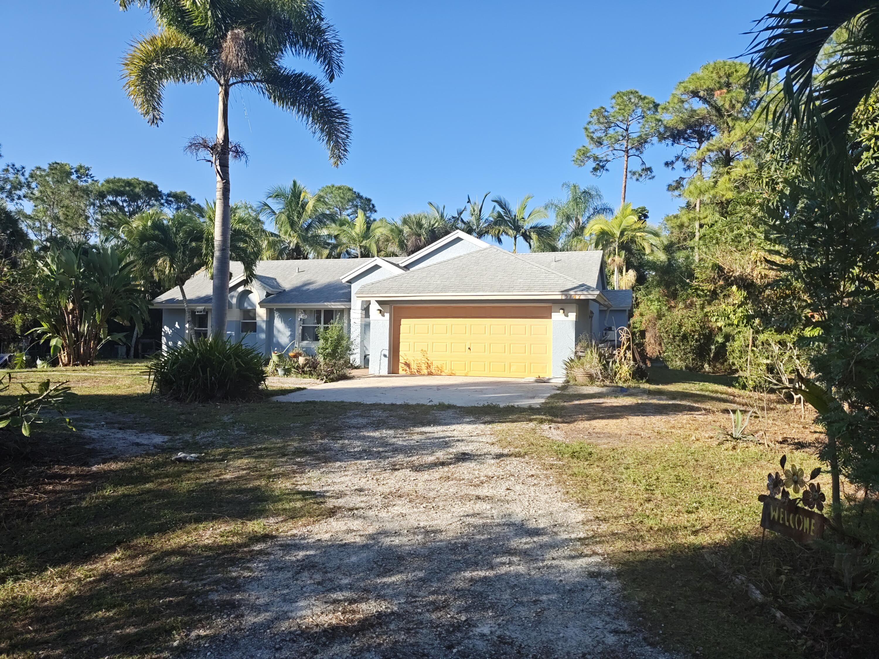 13747 42nd Road North Royal Palm Beach, FL 33411 - Photo 4 of 31 a view of a house with a yard and garage