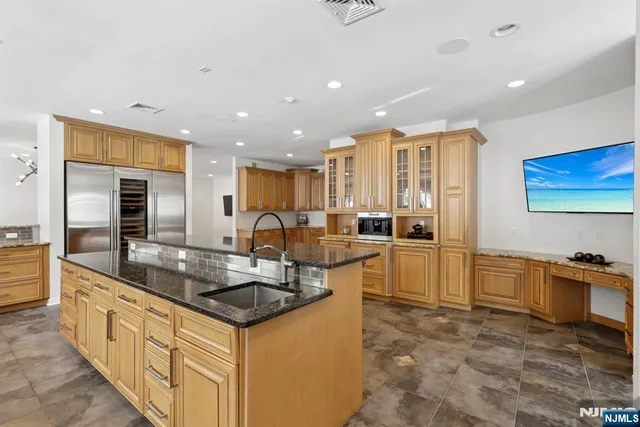 a kitchen with stainless steel appliances granite countertop a sink stove and cabinets