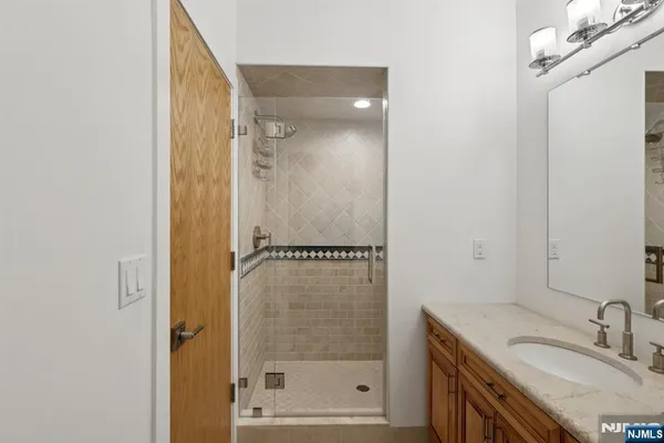 a bathroom with a shower sink and mirror