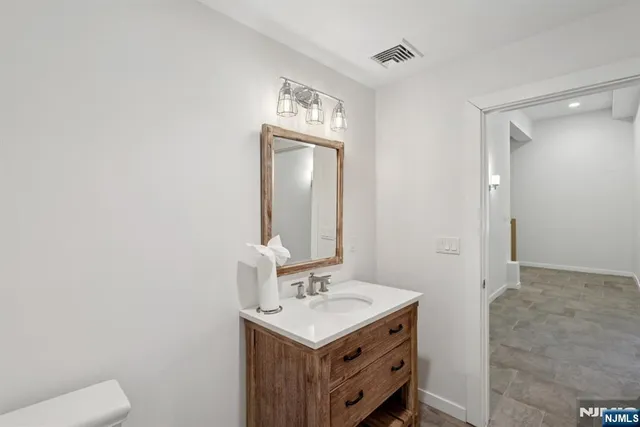 a bathroom with a sink a toilet and mirror