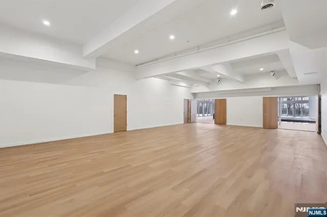 an empty room with wooden floor and window
